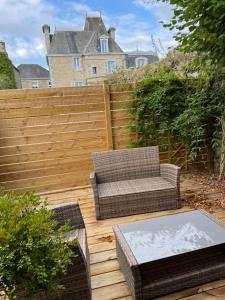 a patio with a chair and a table and a fence at Maison La Tour in Dinan