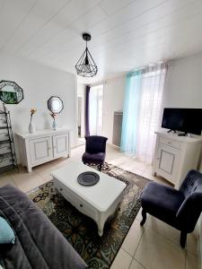 een woonkamer met een bank en een salontafel bij Gîte la Belle Vallée maison indépendante 80m2, 2 chambres à 10 min du Puy du Fou in Treize-Vents
