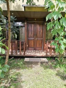 un porche delantero de una casa con puerta de madera en Cabinas Vista Miravalles, en Bijagua