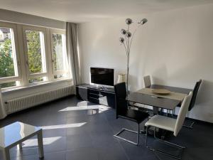 une salle à manger avec une table, des chaises et une télévision dans l'établissement CENTRO Appartamento Ascona, à Ascona
