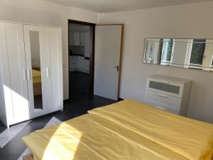 ein Schlafzimmer mit einem Bett mit einem gelben Laken darauf in der Unterkunft CENTRO Appartamento Ascona in Ascona