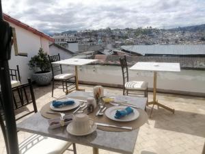 a table on a balcony with a view of a city at Adamas House Hotel Boutique in Quito