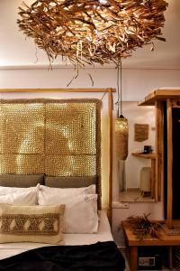 a bedroom with a bed with a gold head board at Angelos Design Suites in Patitiri