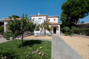 a large white house with a garden in front of it at Villa Wilker in Vilamoura