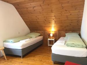 two beds in a room with a wooden ceiling at Townus Apartments Heidenrod in Zorn