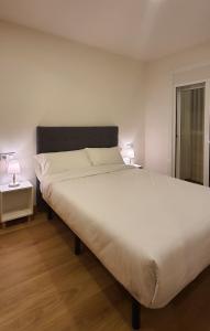 - une chambre avec un grand lit blanc et deux lampes dans l'établissement APARTAMENTO FRANJA 50 Gastromaar, à La Corogne