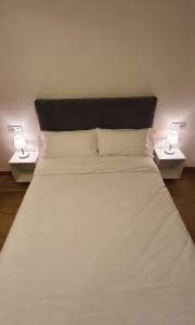 - un grand lit blanc avec deux lampes de chaque côté dans l'établissement APARTAMENTO FRANJA 50 Gastromaar, à La Corogne