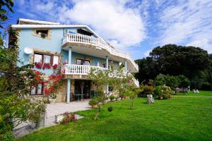 a blue house with flowers on the side of it at El BurbyI in Somo