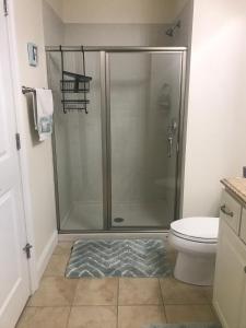 a bathroom with a shower with a toilet and a rug at Ocean Front condo in the heart of Hampton Beach in Hampton
