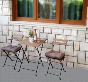a table with two chairs and a bottle of wine at Apartment Neretva in Čapljina
