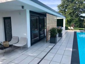 a patio with two chairs and a swimming pool at Guesthouse Passau in Passau
