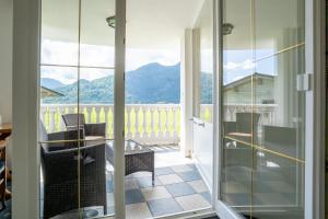a room with a balcony with a view of the mountains at Posthotel Erlerwirt in Erl