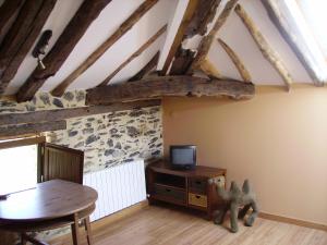 Habitación con mesa y TV en el ático en Casa Rural Pikatzaenea en Sopuerta