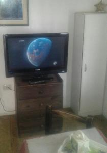 TV de pantalla plana en la parte superior de un soporte de madera en Las Cuatro Estaciones en San Rafael