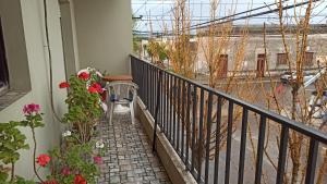 einen Balkon mit einem Tisch und Blumen darauf in der Unterkunft Departamento 2 ambientes 1er piso in Gualeguay