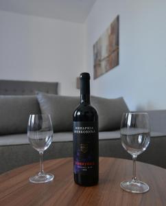 eine Flasche Wein auf einem Tisch mit zwei Weingläsern in der Unterkunft Lux Pegaz 008 in Vrnjačka Banja