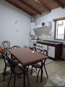 a kitchen with a table and chairs and a stove at AMANECERES LAS GRUTAS II in Las Grutas +22 photos