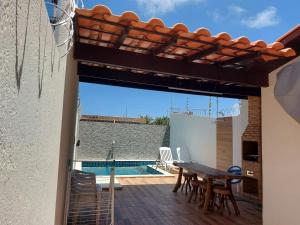 a patio with a table and chairs and a pool at Casa Barra de São Miguel 4 quartos - BarraMar in Barra de São Miguel