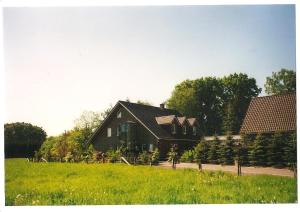 a large house in a field next to a house at Gästehaus Hankhausen in Rastede