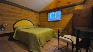 a bedroom with a bed and a table and a window at Parque Girasoles Balneario & Cabañas in San Francisco del Rincón