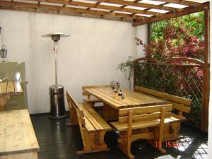 a wooden table and benches on a patio at Viesu Nams Mežu 13 in Ventspils