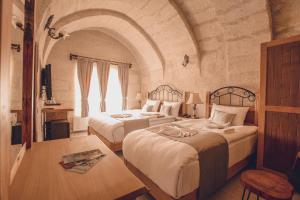 two beds in a room with an archway at Rose Valley Hotel in Goreme