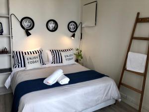 1 dormitorio con 1 cama con almohadas blancas y negras en V&S Hostel Boutique en Buenos Aires
