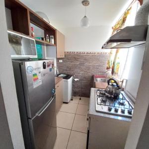 cocina con nevera de acero inoxidable y fogones en Departamento a pasos del borde costero en condominio privado, en La Serena