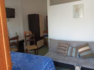 een woonkamer met een bank en een stoel bij LA CABAÑA DE HUERTAMAR in Zorritos