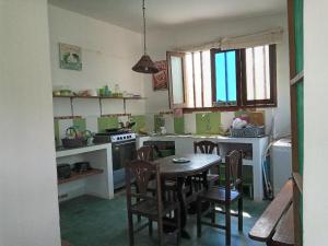 a kitchen with a table and chairs in it at LA CABAÑA DE HUERTAMAR in Zorritos