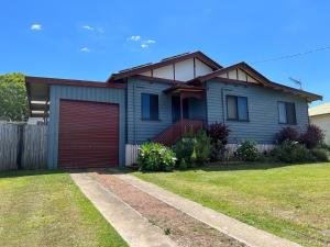 una casa azul con garaje rojo en Cottage on Herbert en Ravenshoe