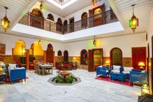 une grande chambre avec des tables et des chaises dans un bâtiment dans l'établissement Riad Lakhdar, à Marrakech