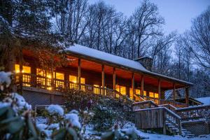 Mount Mitchell Eco Retreat في Busick: مبنى كبير مع إضاءة في الثلج