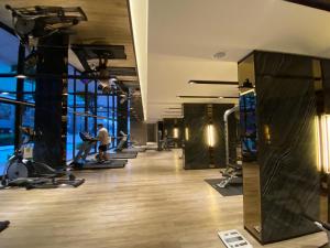 a gym with treadmills and people exercising in it at Politan Breeze, Chaophraya River view in Ban Sai Ma