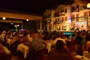 a group of people sitting at tables at a restaurant at night at Hotel Pirat in Kalkan