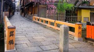 an alley with a wooden fence and a stone sidewalk at Kyoto Inn Gion The Second in Kyoto