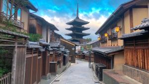 an alley with buildings and a pagoda in the background at Kyoto Inn Gion The Second in Kyoto