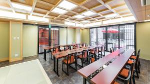 a dining room with tables and chairs and windows at Kyoto Inn Gion The Second in Kyoto