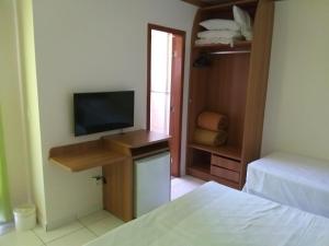 Zimmer mit einem TV, einem Bett und einem Schlafzimmer. in der Unterkunft Golden dolphin grand hotel 1025 in Caldas Novas