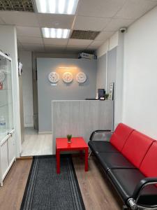 イルクーツクにあるHostels Rus Irkutskの長椅子と赤いテーブルが備わる待合室