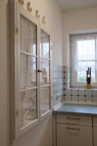 a kitchen with a glass cabinet and a window at Seeblick - a27007 in Büsumer Deichhausen