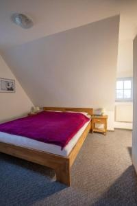 a bedroom with a bed with a purple blanket at Seeblick - a27007 in Büsumer Deichhausen
