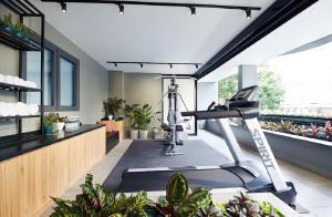 a gym with a treadmill in a room with plants at The Initial Residence in Singapore