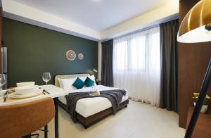 a bedroom with a bed and a table and a window at The Initial Residence in Singapore