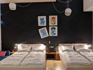 two beds in a bedroom with black walls at Ttdropin Homestay in Taitung City