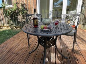 a table with a bottle of wine and a bowl of fruit at Majellon Appartement Sud in Sainte-Christie-dʼArmagnac