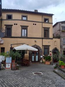 Vignanello的住宿－B&B A due passi dal Castello，前面有一把伞的大建筑