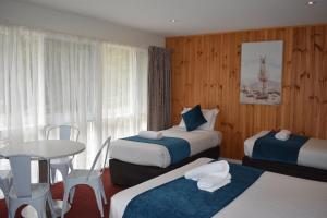 a hotel room with two beds and a table at Sanctuary House Resort Motel in Healesville +64 photos