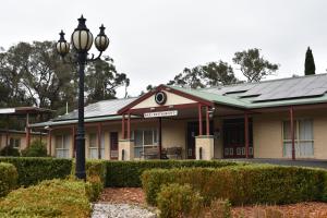 a large building with a tree in front of it at Sanctuary House Resort Motel in Healesville