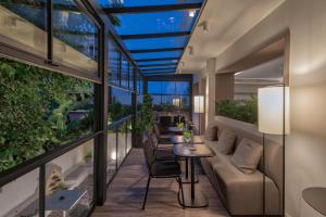 einen Balkon mit einem Sofa, Tischen und Stühlen in der Unterkunft Bitzaro Boutique Hotel in Zakynthos